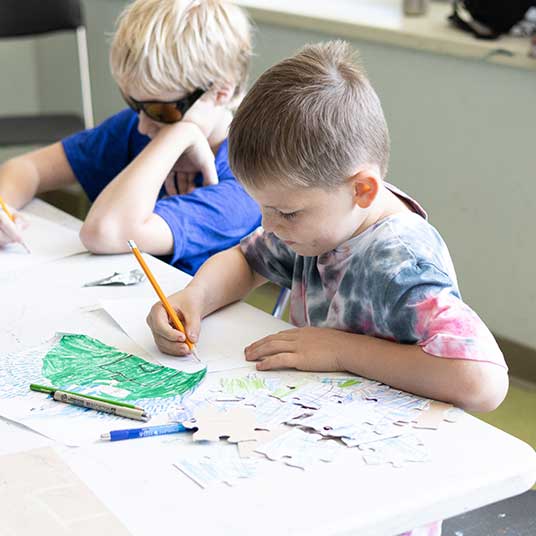 Camper using pencil to draw during camps